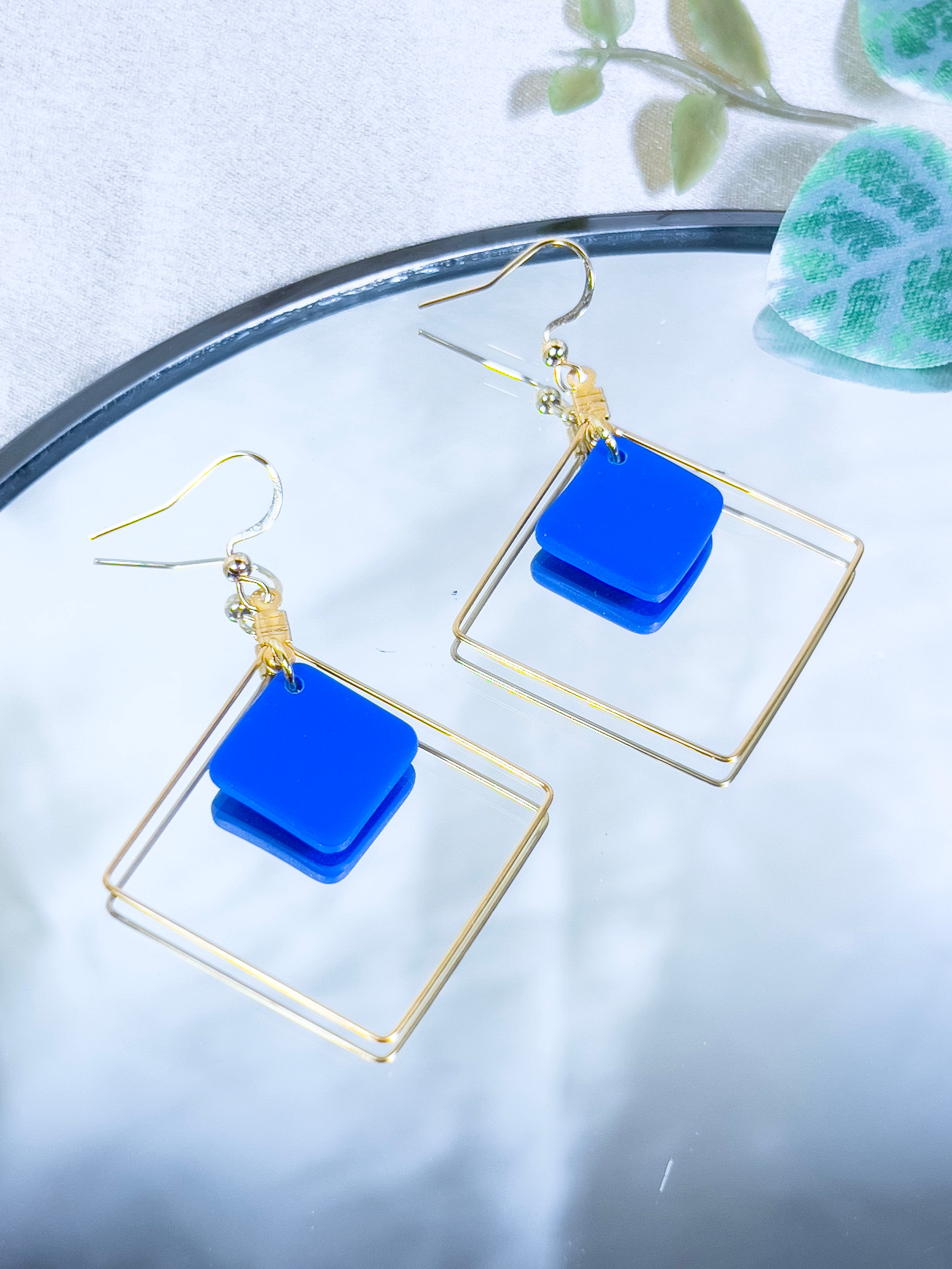 Boucles d'oreilles artisanales fantaisie, créoles carrée en acier inoxydable doré avec carré bleu suspendu à l'intérieur