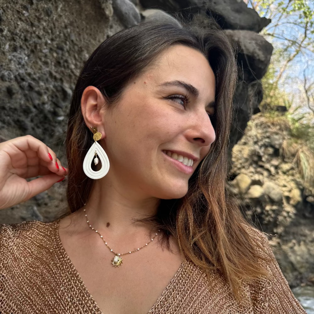 bijoux boucles d'oreilles en forme de gouttes, de couleur blanche et doré, avec une perle d'eau douce suspendu au centre de la goutte. Puce dorée en acier inoxydable. Image